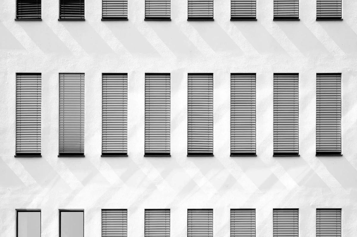 White building facade with rows of shuttered windows